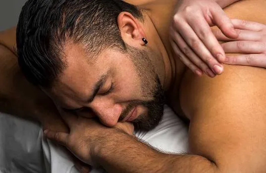 Salle de massage avec lumières tamisées et musique douce pour une ambiance relaxante